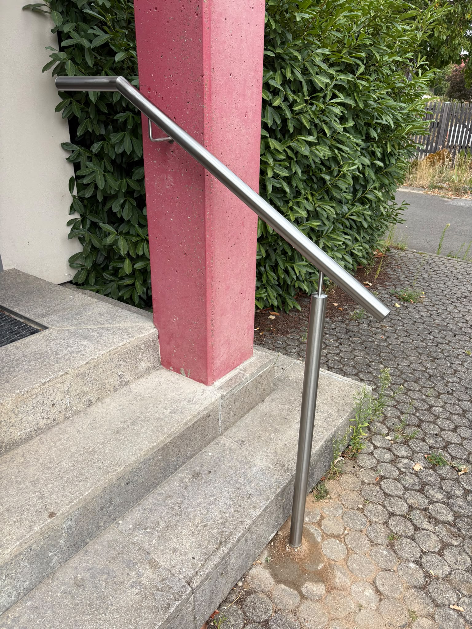 Edelstahl-Handlauf an Eingangstreppe mit Betonstuetze