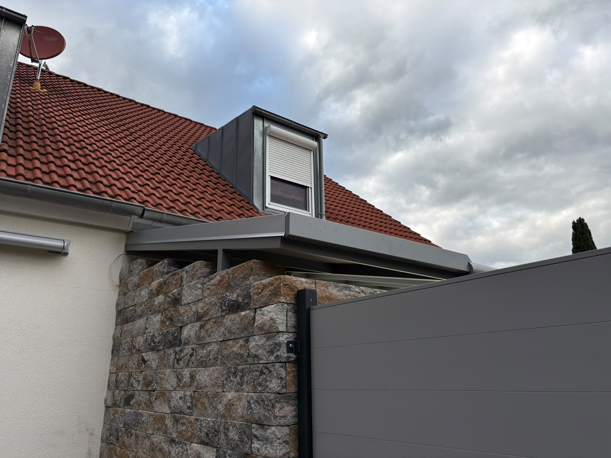 Vordach-Verblechung an Natursteinmauer mit Sichtschutz