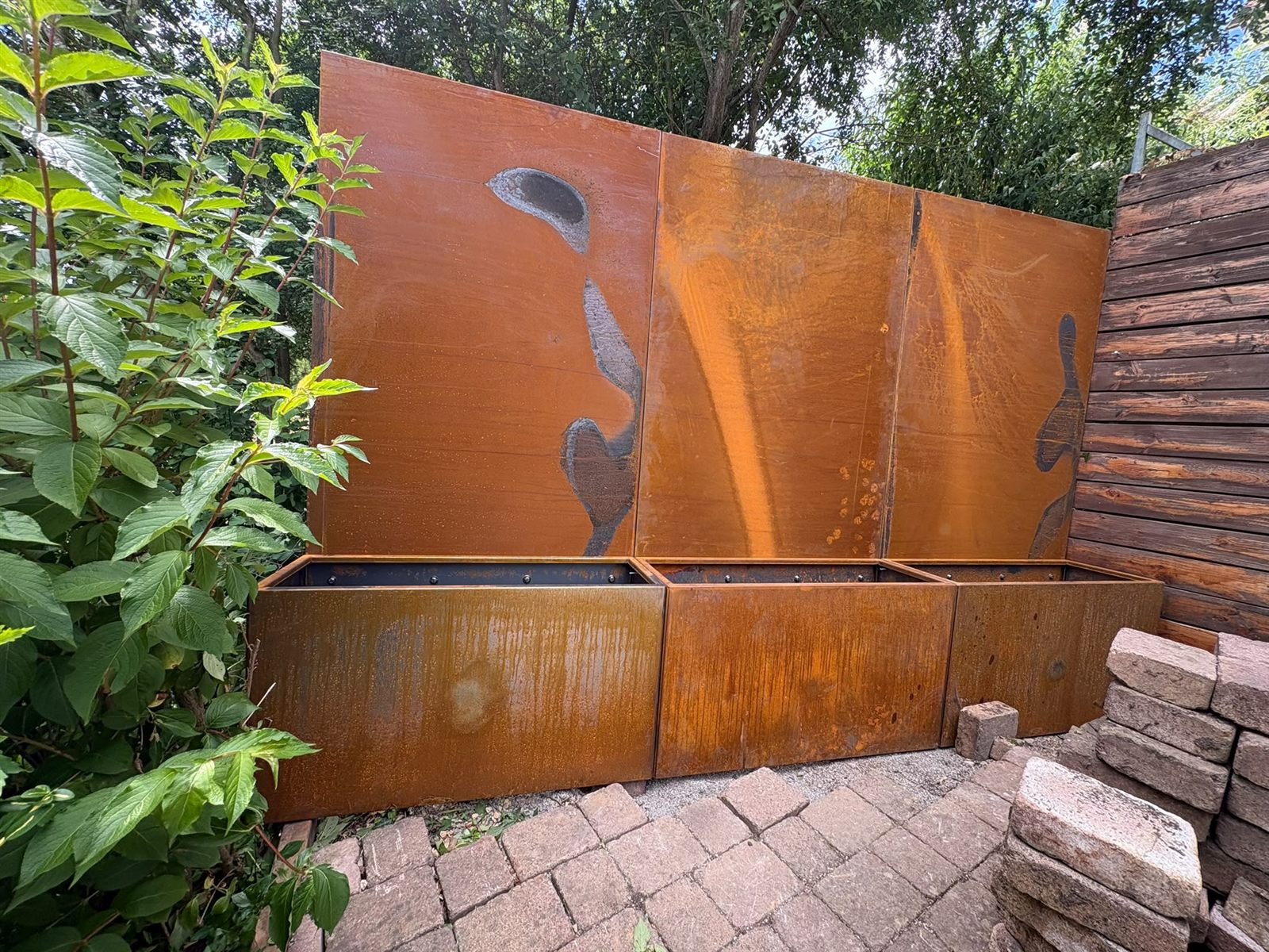 Sichtschutzwand aus Cortenstahl mit integrierten Pflanzkästen