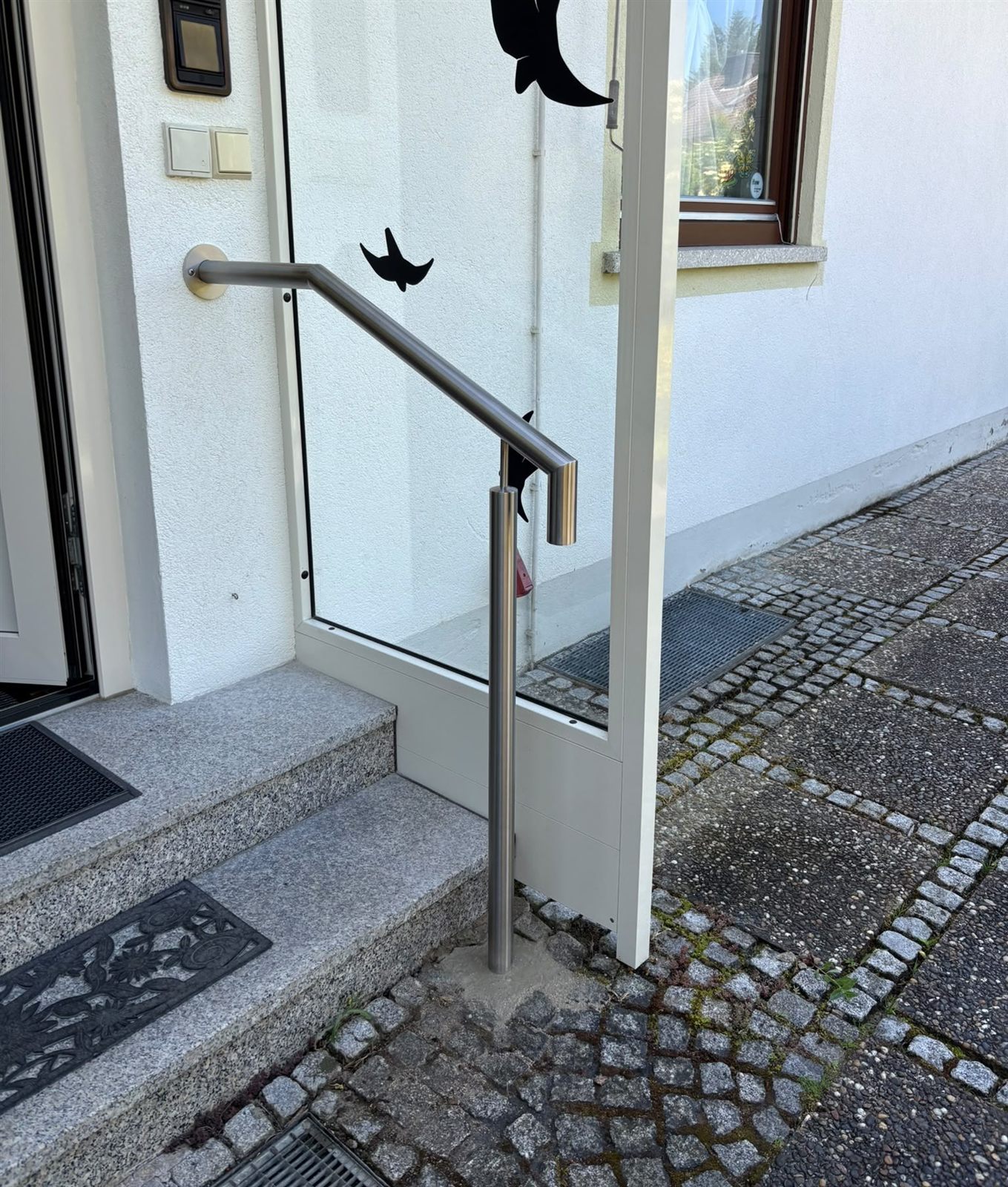 Edelstahl-Handlauf an gepflasterter Eingangstreppe